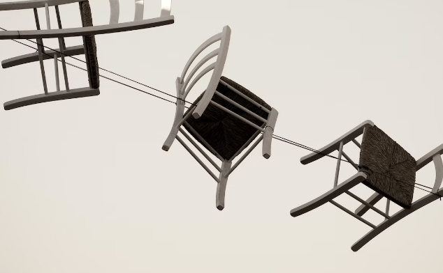Stoelen hangen ondersteboven aan draden tegen een lichte achtergrond.